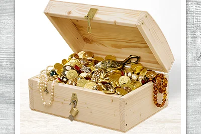 Offene Schatztruhe gefüllt mit Goldmünzen und Schmuck